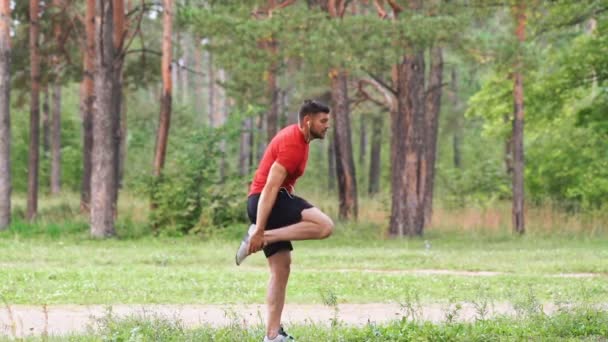 Sporcu Parkta Koşmadan Önce Bacak Kaslarını Esnetir Yavaş Çekim — Stok video