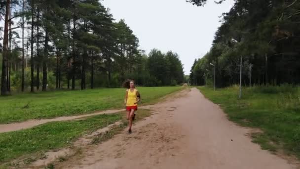 一个女人独自在森林里沿着大路跑 户外运动 无人机射击 — 图库视频影像