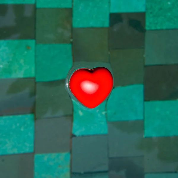 Röd gummi hjärtat i vattnet — Stockfoto