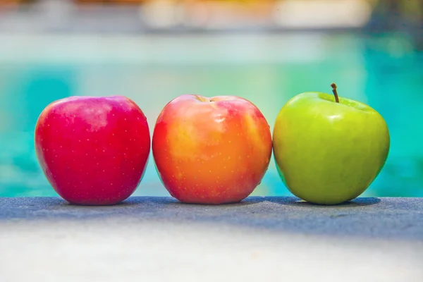 Three apples on a poolside — Stock Photo, Image