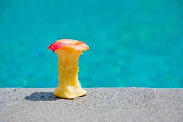 Apple core on a poolside — Stock Photo, Image