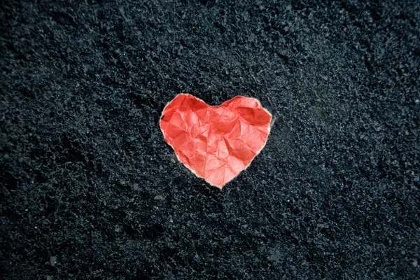 Paper heart on the stone black floor — Stock Photo, Image