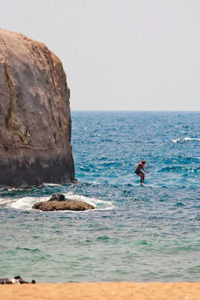Homem pulando da rocha — Fotografia de Stock