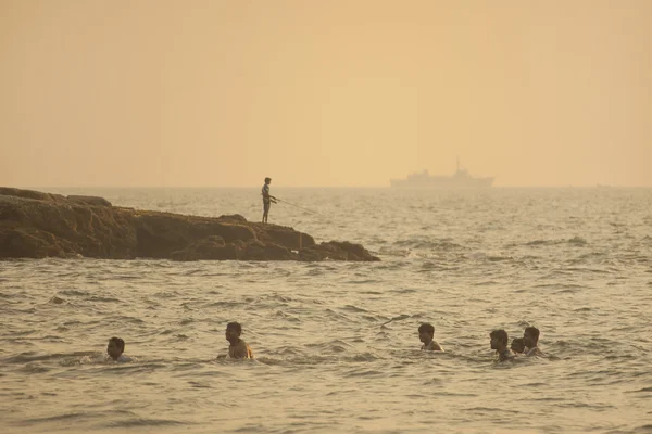 Menino pescador e um grande navio — Fotografia de Stock