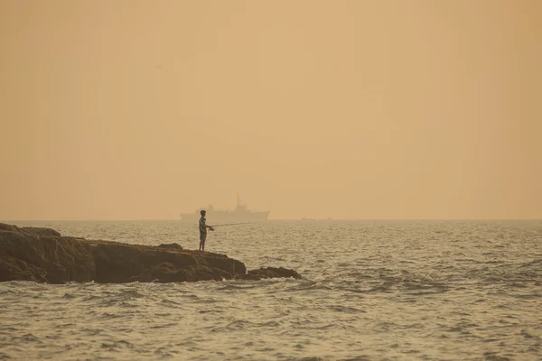 Boy fisherman and a large ship — Stock Photo, Image