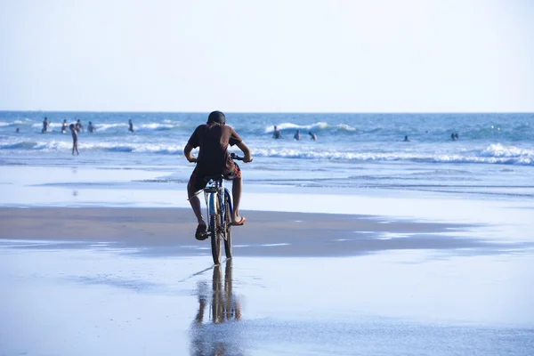 Man op de fiets rijden langs het strand. — Stockfoto