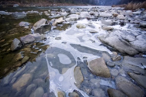 Frozen river with stones — Stock Photo, Image