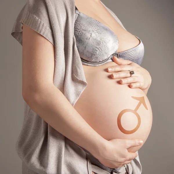 Беременная женщина с символом — стоковое фото