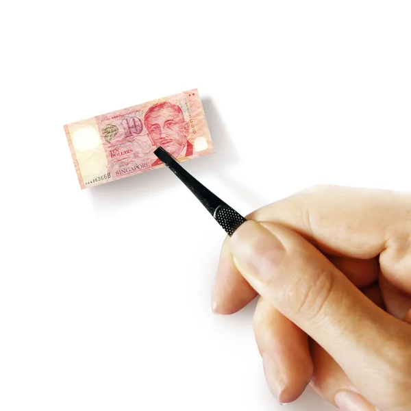 Hand with a pincet holding small banknote — Stock Photo, Image