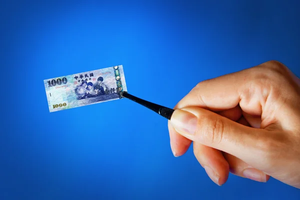 Hand with a pincet holding small banknote — Stock Photo, Image