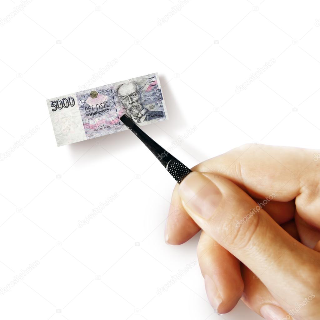 hand with a pincet holding small banknote