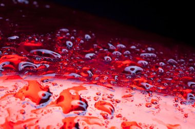 Water drops on red metal surface