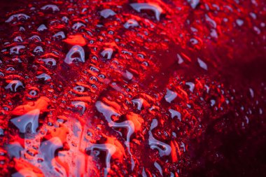 Water drops on red metal surface