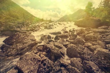 Rocky river with mountains on background