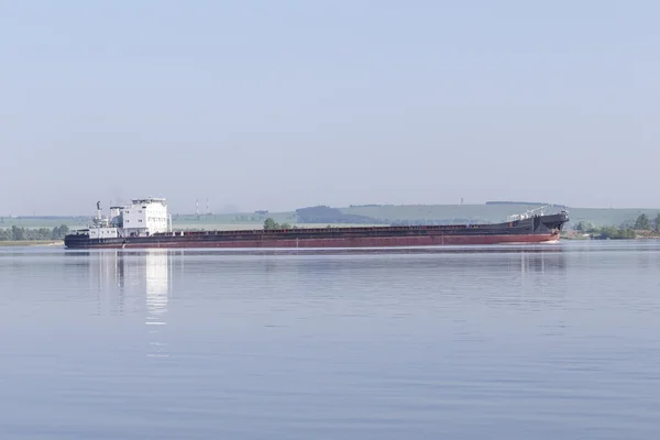 Длинный грузовой корабль на большой реке — стоковое фото