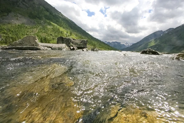 Rocky river with mountains on background — Stock Fotó