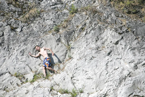 Junger Mann posiert auf grauem Felsen — Stockfoto