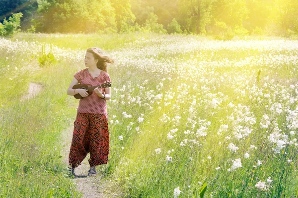 Meisje op weide met ukulele — Stockfoto