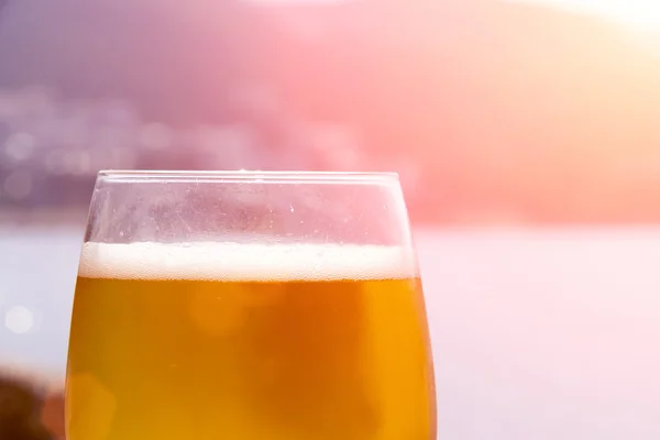 Bicchiere di birra con mare sullo sfondo — Foto Stock