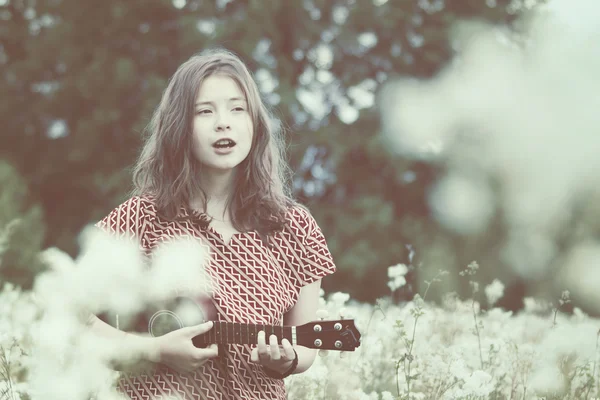 Ragazza sul prato con ukulele — Foto Stock