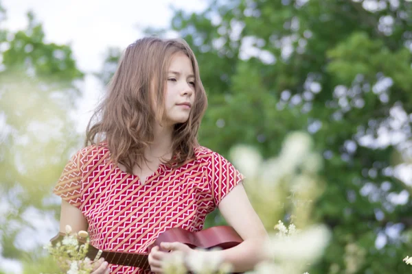 Menina no prado com ukulele — Fotografia de Stock