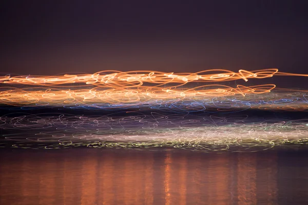 Размытые, цветные огни над водой — стоковое фото