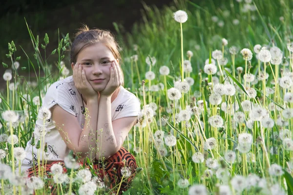 Ragazza carina giocare con i denti di leone — Foto Stock