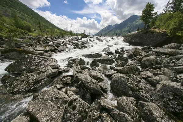 Rio rochoso com montanhas no fundo — Fotografia de Stock