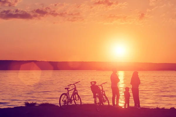 Famiglia con biciclette sulla riva del fiume — Foto Stock