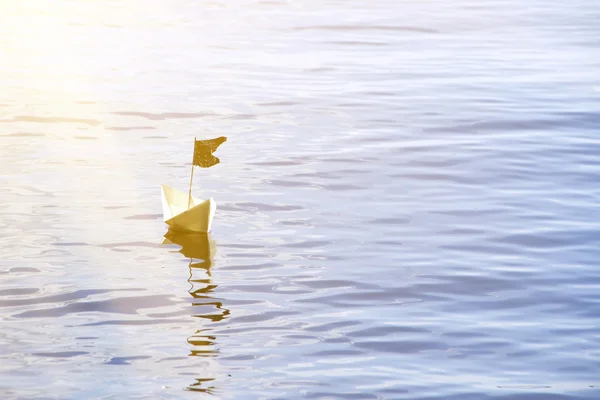 Бумажная лодка с флагом на воде — стоковое фото
