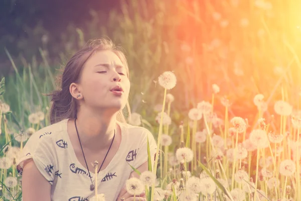 Ragazza carina giocare con i denti di leone — Foto Stock