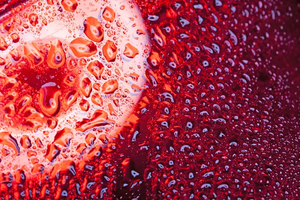 Капли воды на поверхности красного металла — стоковое фото