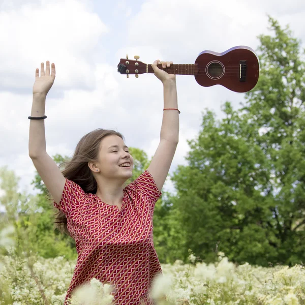 Girl on meadow with ukulele