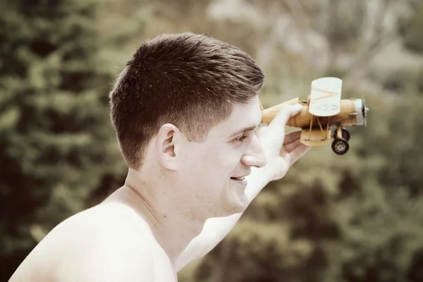 Young man playing with airplane model — Stock Photo, Image