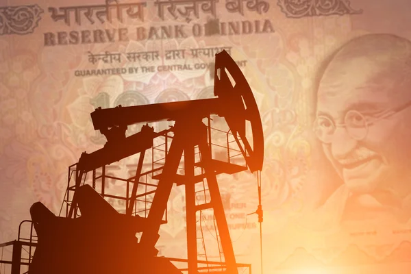 Нефтяной насос с индийской банкнотой — стоковое фото
