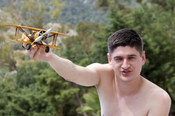 Young man playing with airplane model — Stock Photo, Image