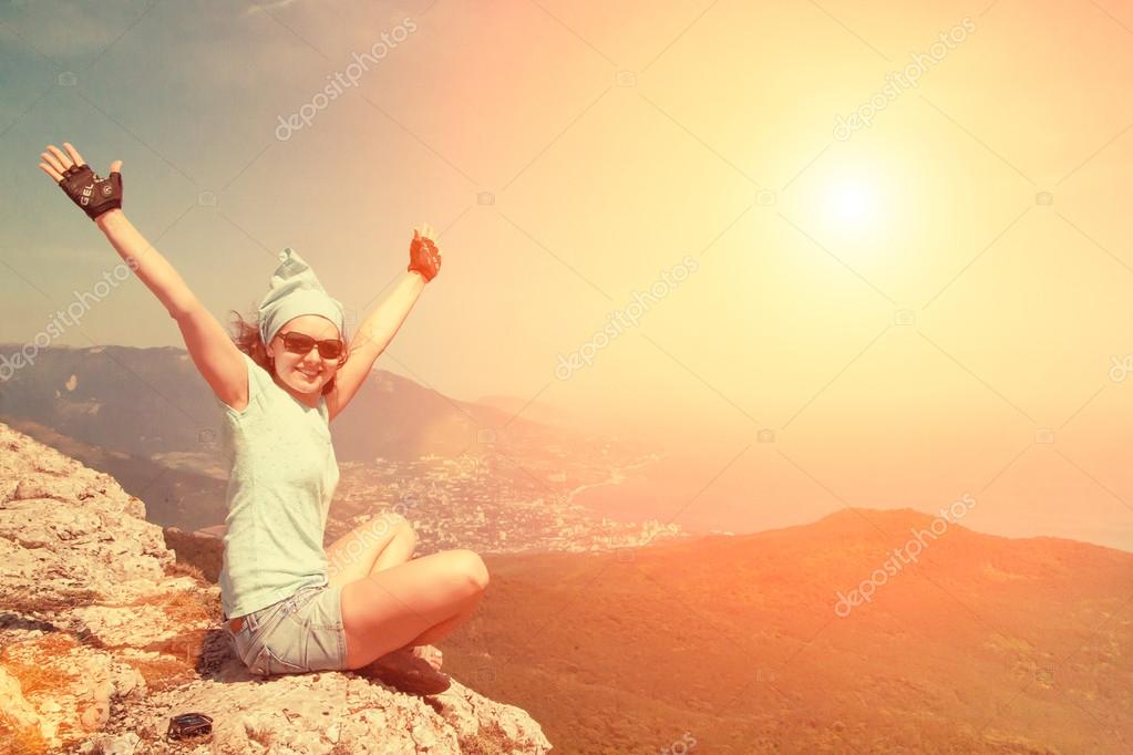 Smiling girl sitting on edge of cliff Stock Photo by ©watman 77266659
