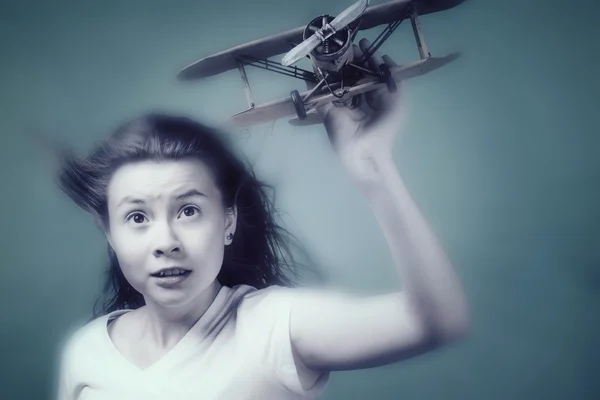 Симпатична дівчина грає з моделлю літака — стокове фото