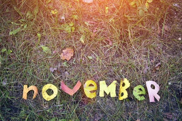 Listopada słowo wycięte z liści jesienią — Zdjęcie stockowe
