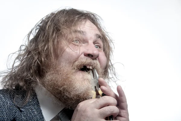 Бородатий чоловік рипляє зуб плоскогубцями — стокове фото