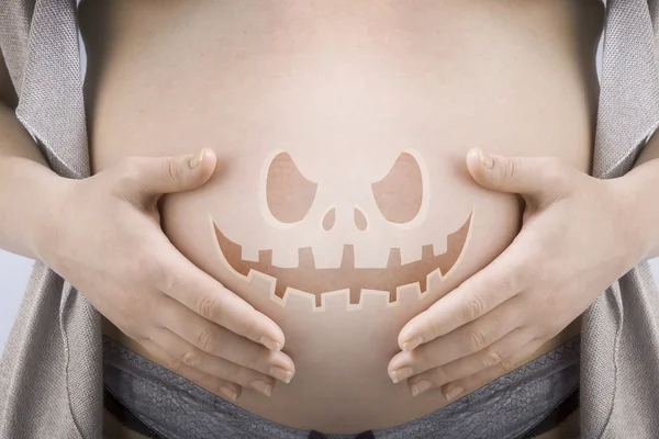 Беременная женщина с хэллоуинским лицом — стоковое фото