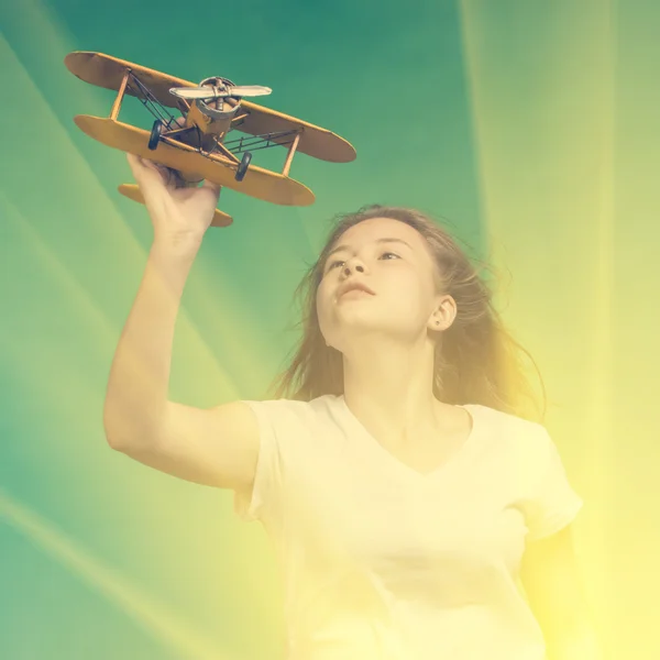 Милая девушка играет с моделью самолета — стоковое фото