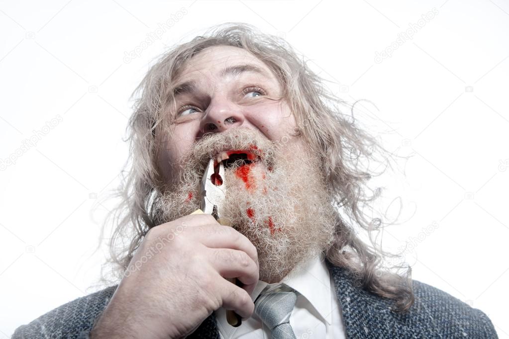 Bearded man rips tooth with pliers