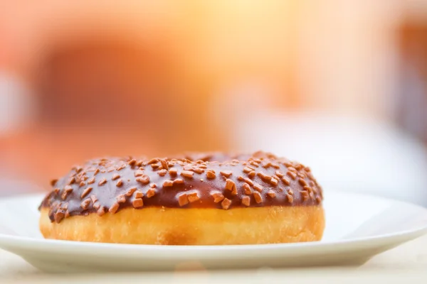 Шоколадний пончик на білій тарілці — стокове фото