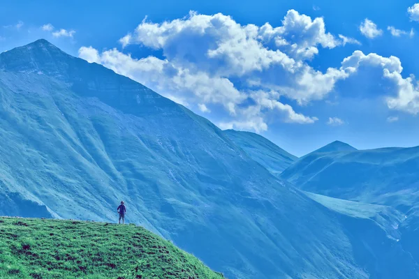 Young girl standing on the top of mountain — Stock Photo, Image