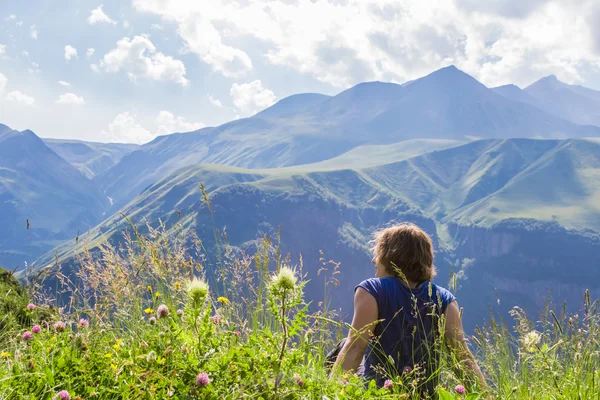 Frau sitzt auf der Spitze eines Berges — Stockfoto