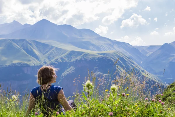 Frau sitzt auf der Spitze eines Berges — Stockfoto