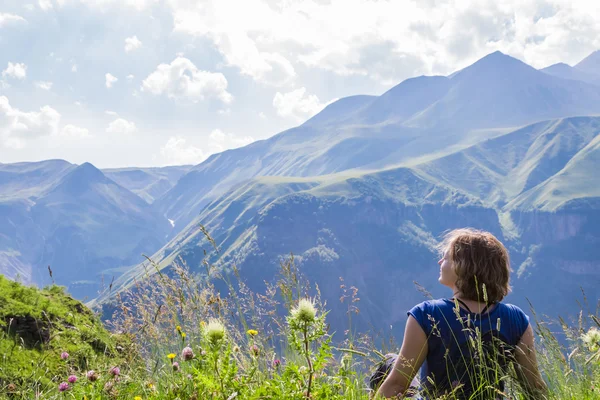 Žena sedí na vrcholu hory — Stock fotografie