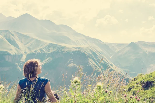 Женщина сидит на вершине горы — стоковое фото