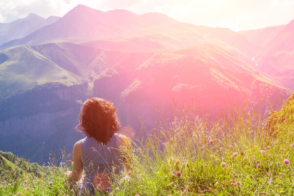 Woman sitting at the top of a mountain